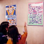 Dos mujeres observan un poster colorido en la exposicion